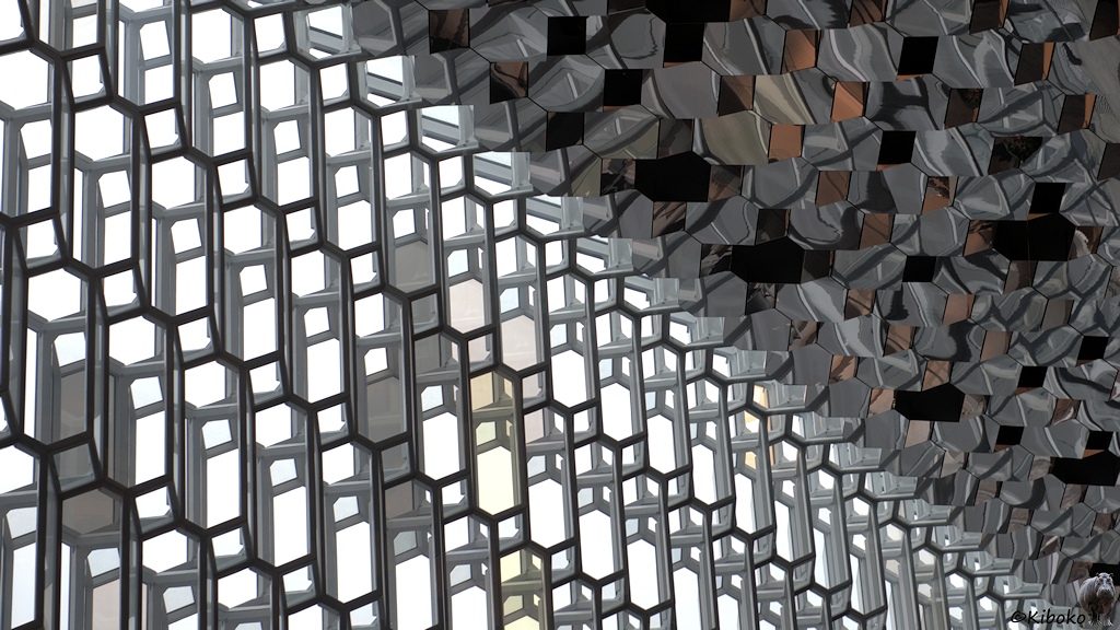 Das Bild ist diagonal geteilt. Im unteren Teil sind kubische Glaselemente. Im oberen Teil sind kubische Spiegelelement.