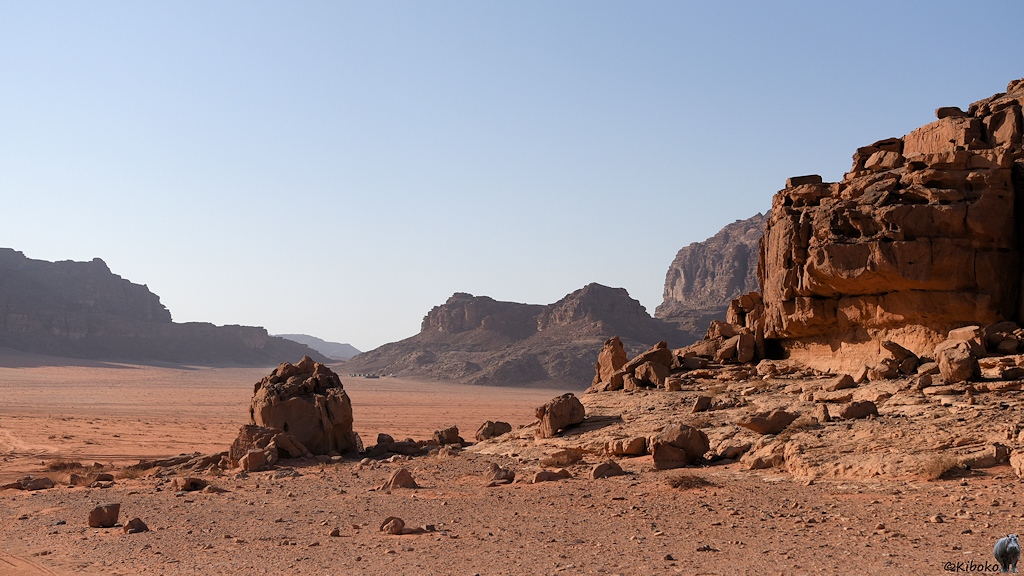 Steine und Felsen in der Wüste mit Camp im Hintergrund