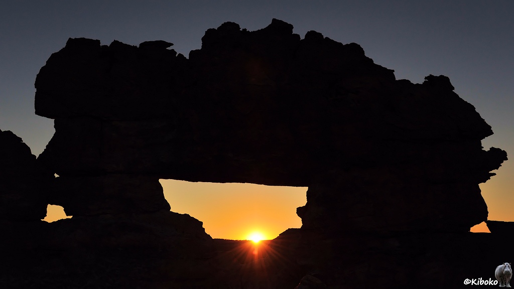Das Bild zeigt nochmal den Felsen mit der natürlichen Brücke im Gegenlicht. Die Sonne geht gerade an der Fensteruterseite unter.