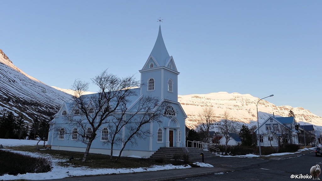 Hellblaue Holzkirche mit weißen Tür- und Fensterrahmen.