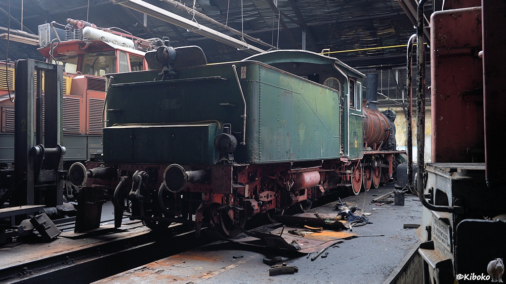 Das Bild zeigt eine vierachsige, grün-schwarze Schlepptenderlokomotive von hinten in einer Werkhalle.