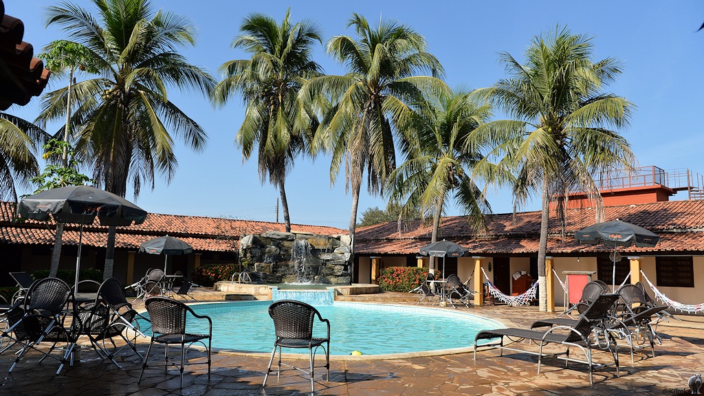 Hotelschwimmbad mit künstlichem Wasserfall vor Palmen