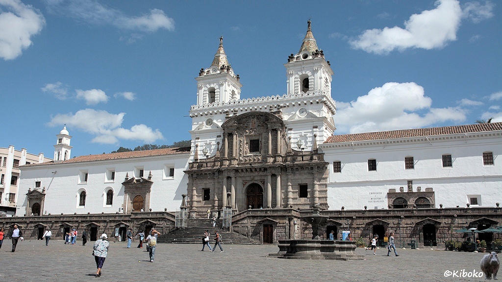Das Bild zeigt einen Platz mit einer Kirche auf einem Podest. Das Podest und das Portal sind aus Vulkangestein. Die beiden Türme über dem Portal und die seitlichen Wände sind weiß gestrichen.