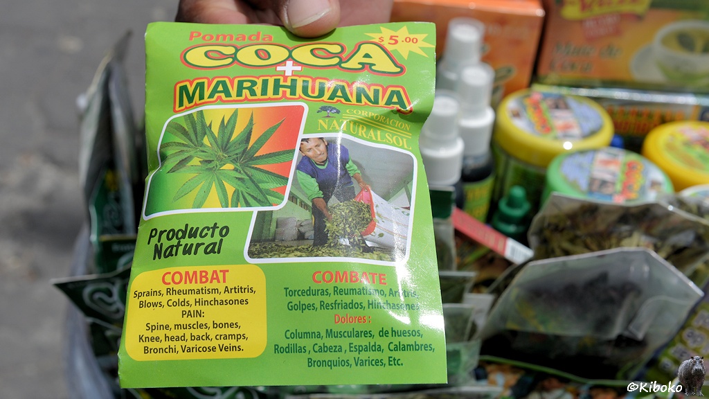 Das Bild zeigt eine kleine grüne Tüte mit der Aufschrift Coca+Marihuana mit Bildern der Pflanzenblätter und eine Liste von Krankheiten.