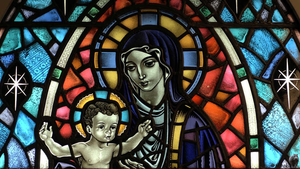 Motiv aus einem bunten Glasfenster zeigt Maria und Jesus.