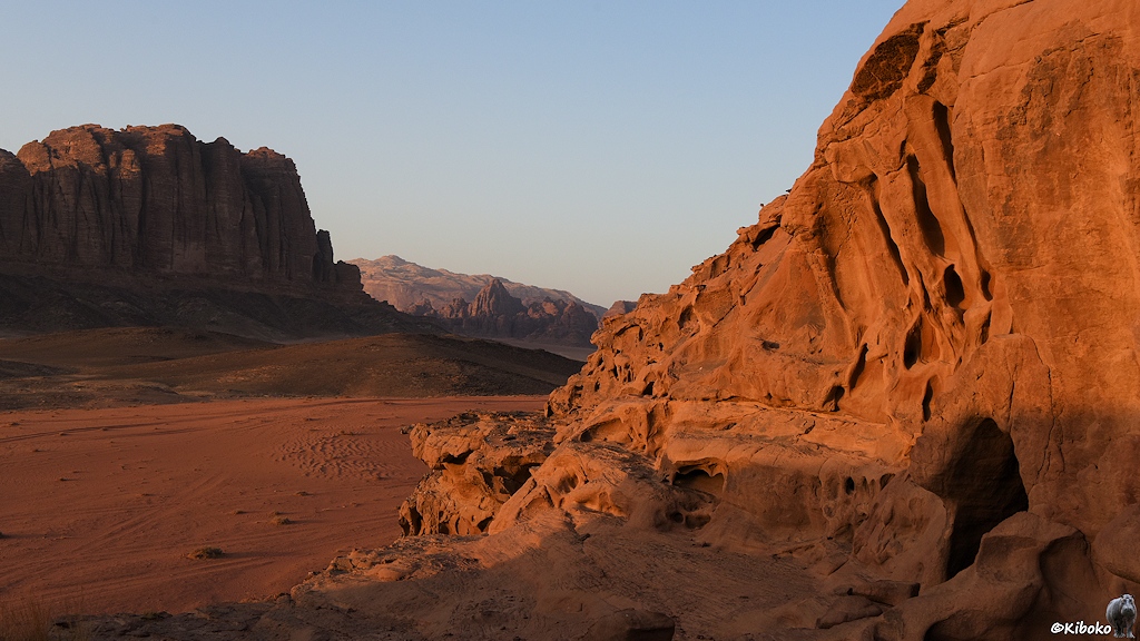Sonnenbeleuchteter Felsen vor Wüstental