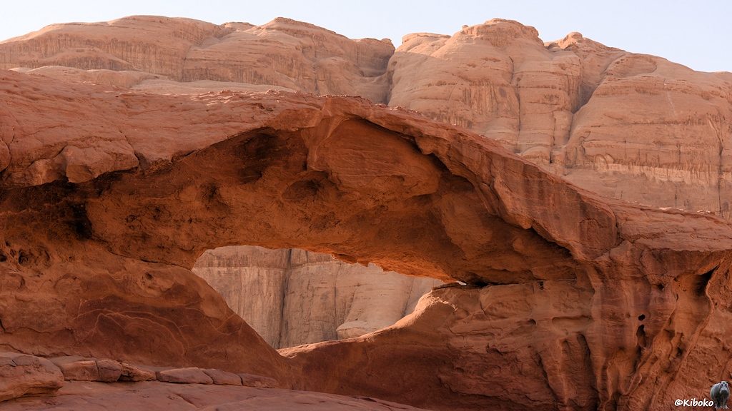 Loch im Sandstein gegen eine dahinterliegende Felswand fotografiert