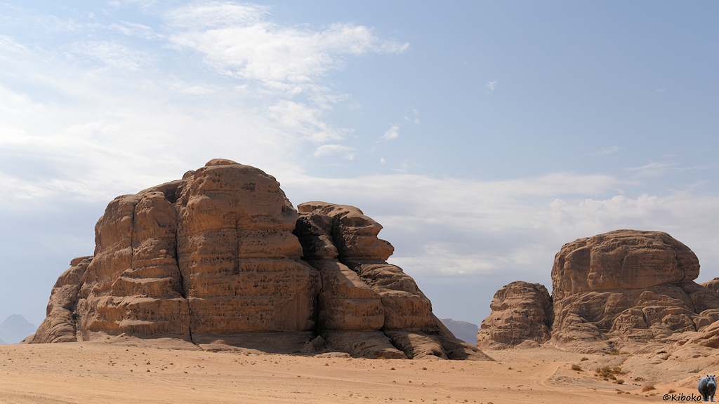 Felsmassiv in der Wüste aus beigefarbenem Sand 