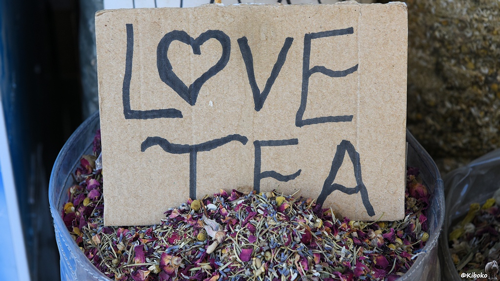 Blaue Tonne mit getrockneten Blüten und einem Pappschild mit der Aufschrift Love Tea