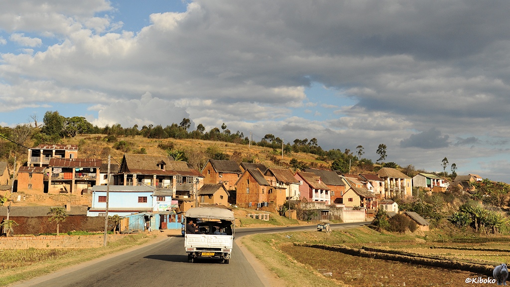 Eine geteerte Straße fürhrt durch ein typisches Dorf