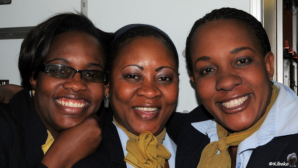 Drei Stewadessen der Air Namibia lächeln zum Abschied in die Kamera.