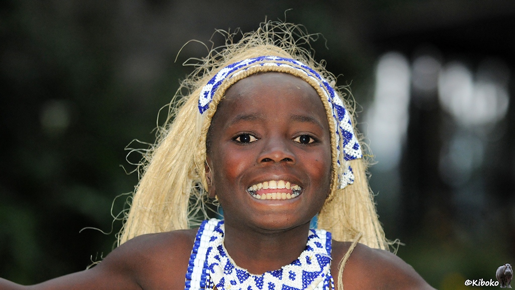 Das Bild zeigt das Porträt eines jungen Tänzers mit langen blonden Haaren aus Fasermaterial .